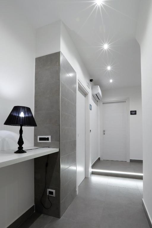 a lamp on a table in a room with a walk in shower at Napoli Vesuvio Apartments by Dimorra in Naples