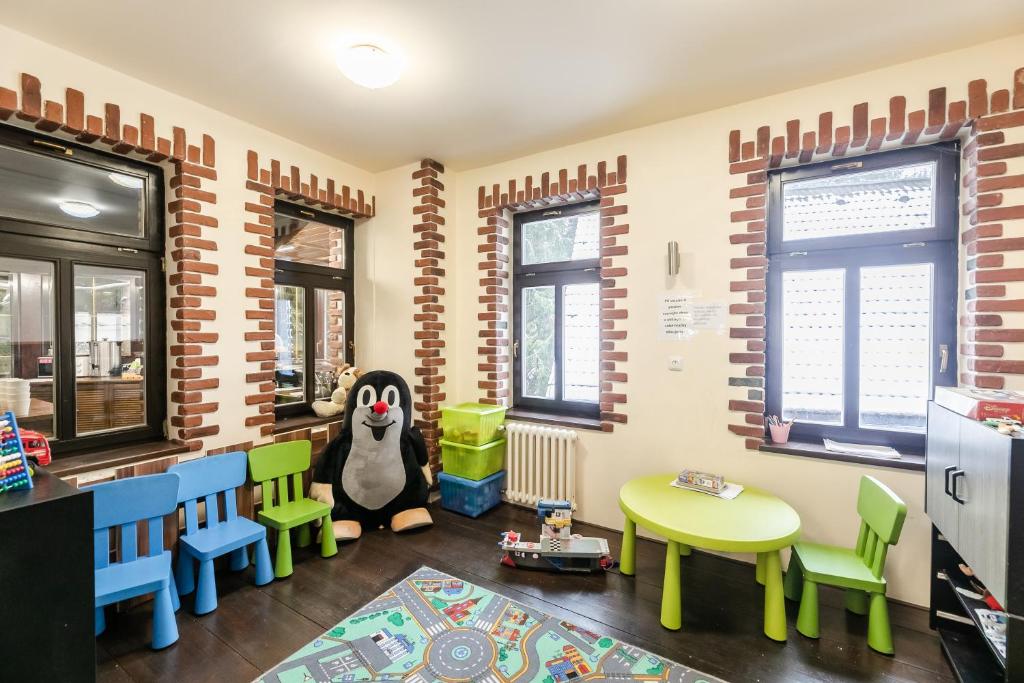 a room with a classroom with a table and a stuffed animal at Hotel Perla Jizery in Josefuv dul