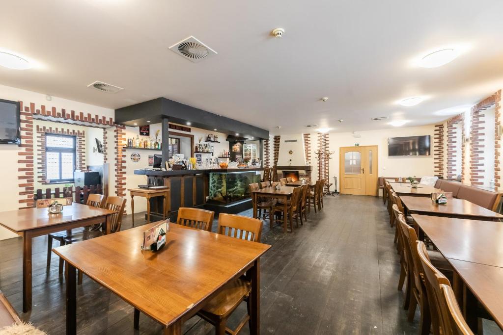 a dining room with wooden tables and chairs at Hotel Perla Jizery in Josefuv dul