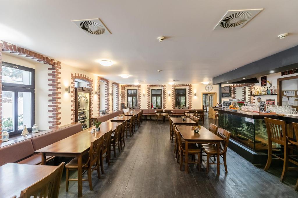 a dining room with wooden tables and chairs at Hotel Perla Jizery in Josefuv dul