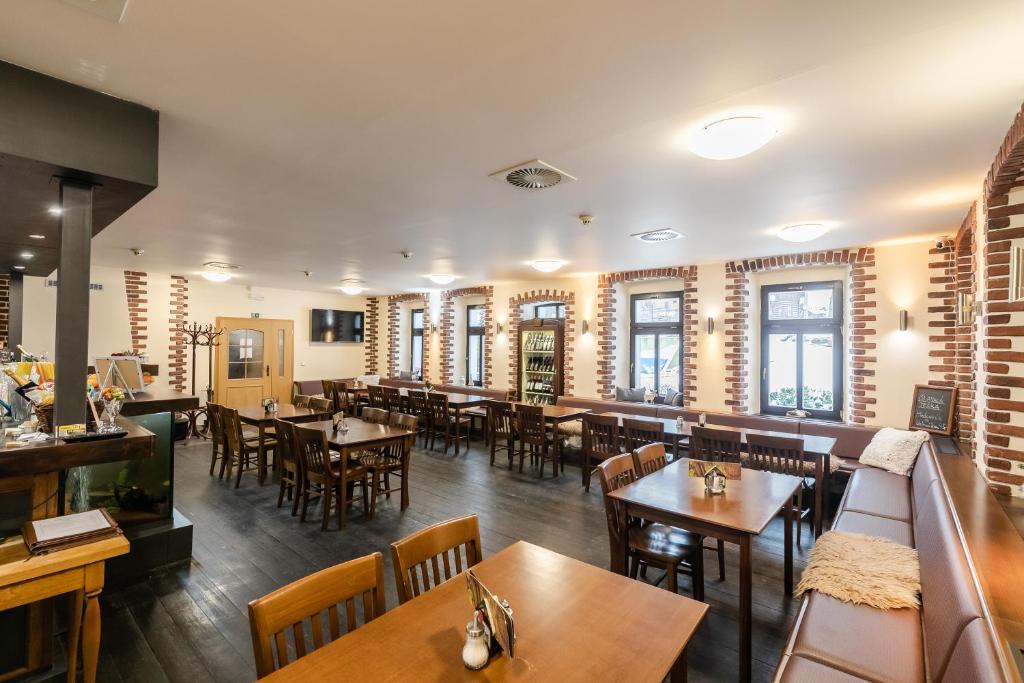 a restaurant with wooden tables and chairs and windows at Hotel Perla Jizery in Josefuv dul