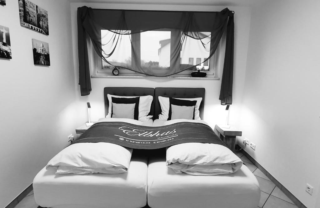 ein schwarz-weißes Foto eines Bettes mit Fenster in der Unterkunft Elbhus Hamburg in Moorwerder
