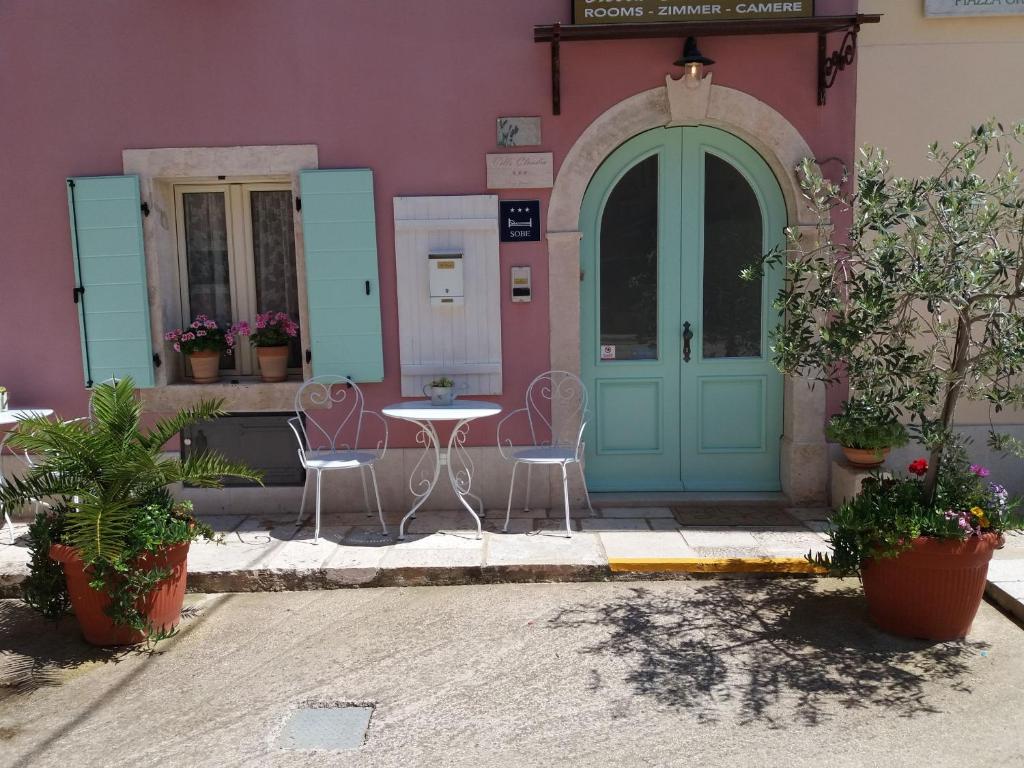 a building with a blue door and a table and chairs at Villa Claudia in Fažana