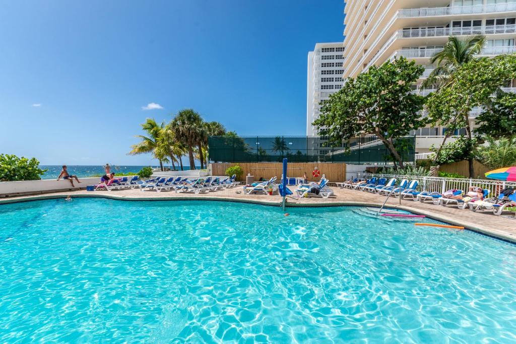 a large swimming pool with chairs and the ocean at Ocean Beach Condo 3BR On the Sand 811 in Fort Lauderdale