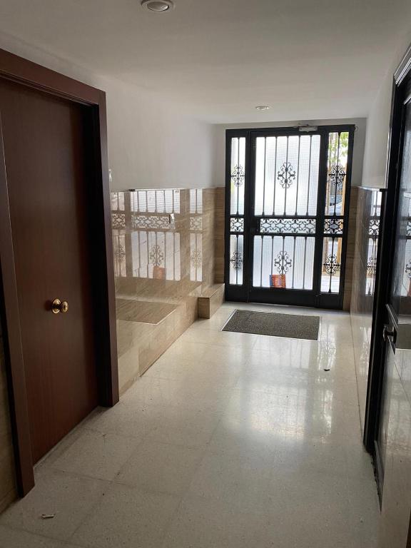 an empty hallway with a door and a window at WISH SUITE NIEBLA DE SEVILLA in Seville