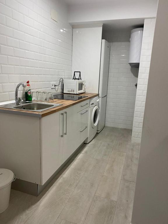 a kitchen with a sink and a washing machine at WISH SUITE NIEBLA DE SEVILLA in Seville