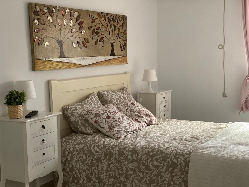 a bedroom with a bed and a painting on the wall at WISH SUITE NIEBLA DE SEVILLA in Seville