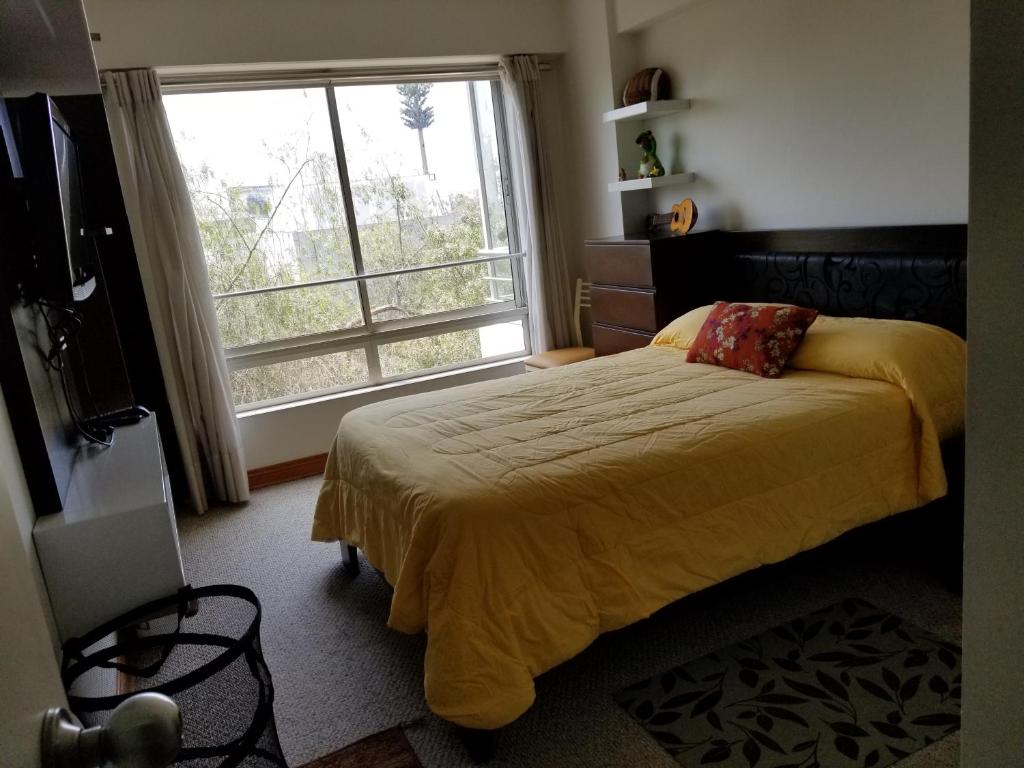 um quarto com uma cama e uma grande janela em Dormitorio Privado dentro de Departamento em Lima