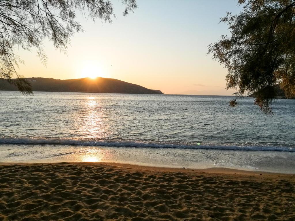 a beach with the sun setting over the water at Alexandros by the Beach - Serifos in Livadakia