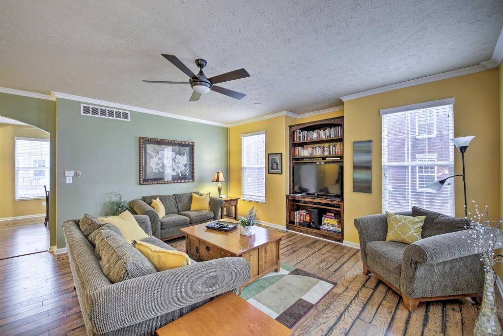 a living room with two couches and a ceiling fan at Arts and Design District Condo Steps to Monon Trail in Carmel