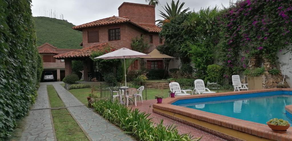 薩爾塔的住宿－馬爾瓦住宿加早餐旅館，一座带游泳池、椅子和遮阳伞的房子