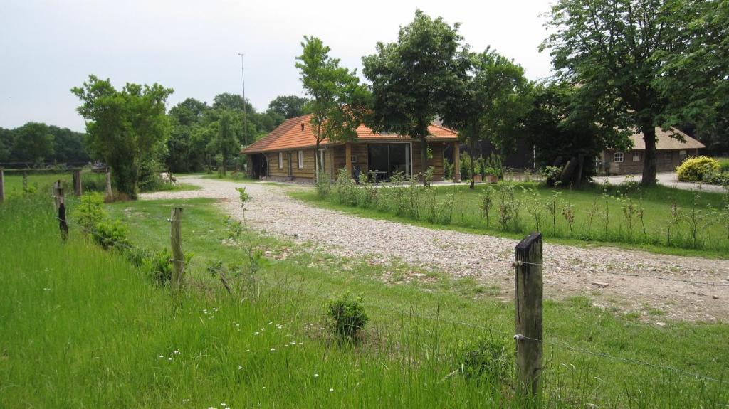 una casa in mezzo a un campo con una recinzione di Boerderij het Reestdal a Linde