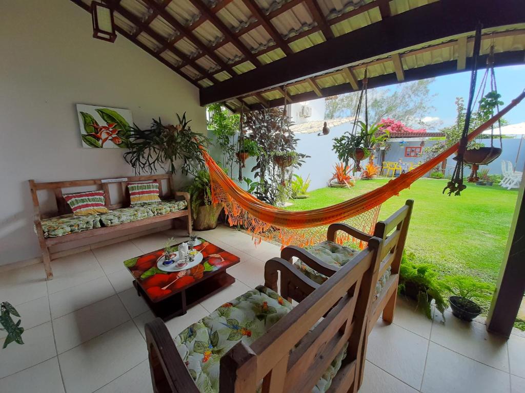 a hammock in a room with a view of a yard at Casa na Praia do Foguete in Cabo Frio