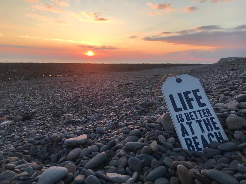 a sign on a beach with the words life is better at the beach at Mona Villa Holiday Home in Coulderton