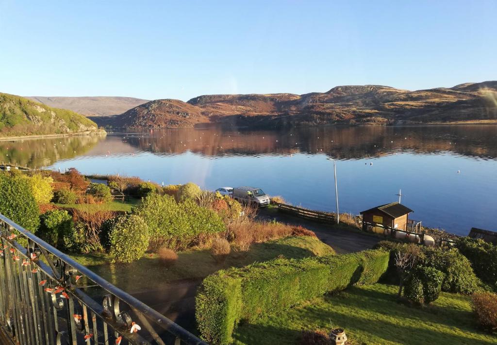 vistas a un lago con una casa en la orilla en Upper Alta Apartment, en Tighnabruaich