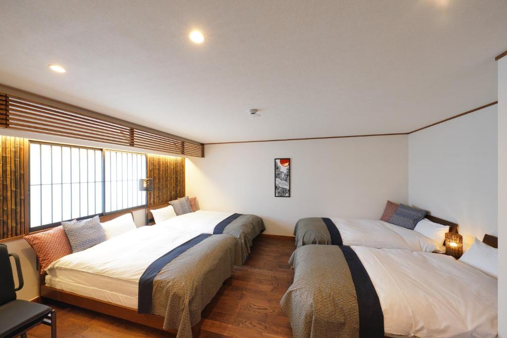 sypialnia z 2 łóżkami i oknem w obiekcie YADOYA Uguisu w Tokio