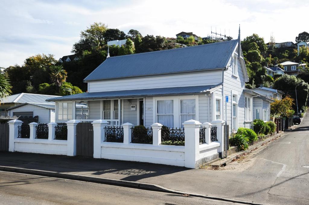 Biały dom z białym płotem na ulicy w obiekcie Puriri Downtown Villa - Napier Holiday Home w mieście Napier