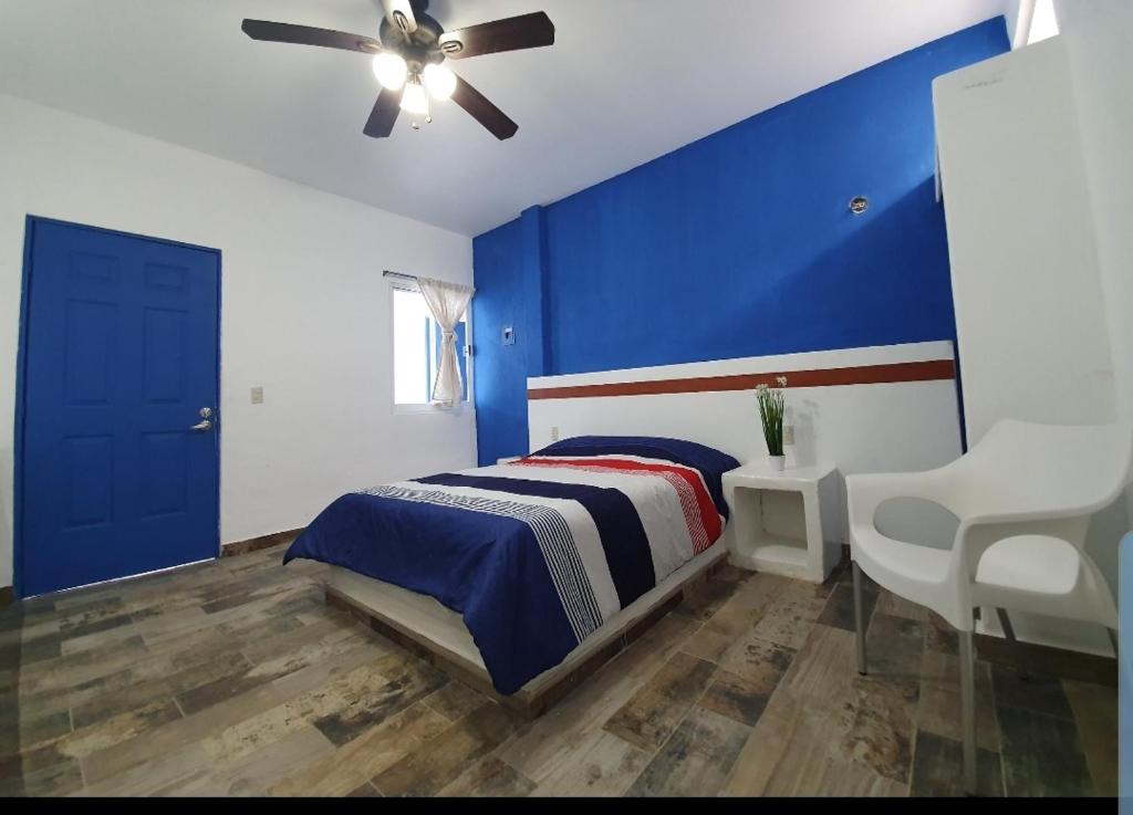 a blue bedroom with a bed and a ceiling fan at Luna Azul in Tapachula