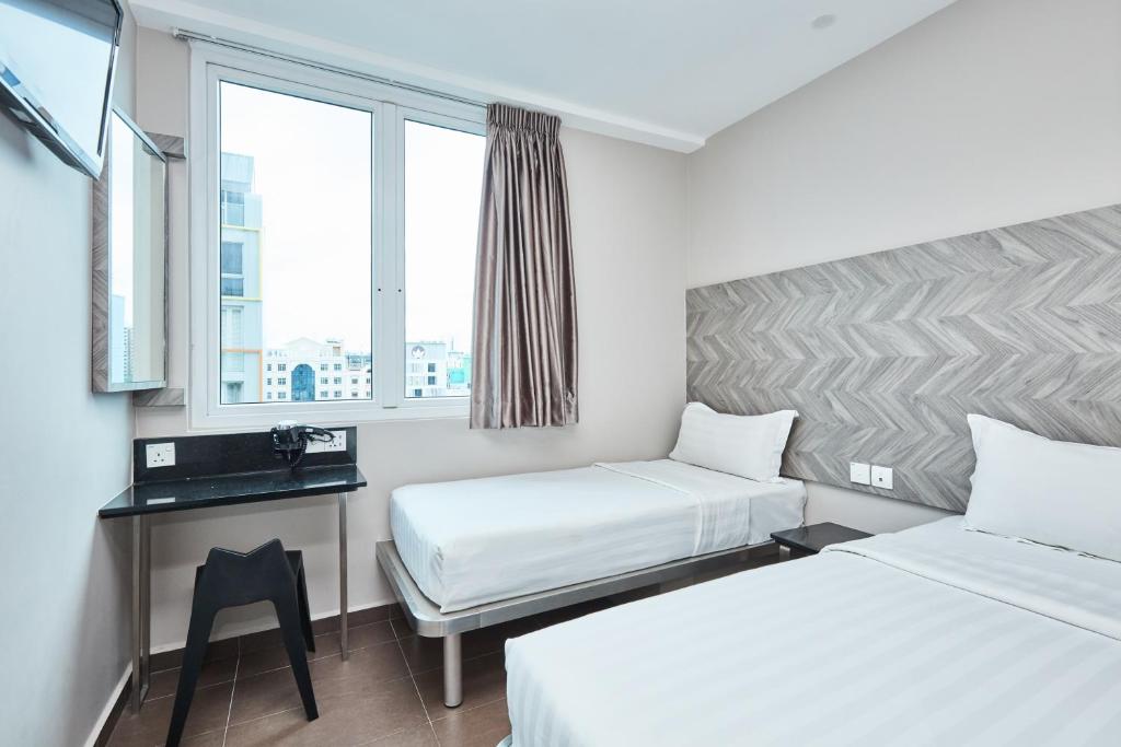 Ein Bett oder Betten in einem Zimmer der Unterkunft ibis budget Singapore Ruby