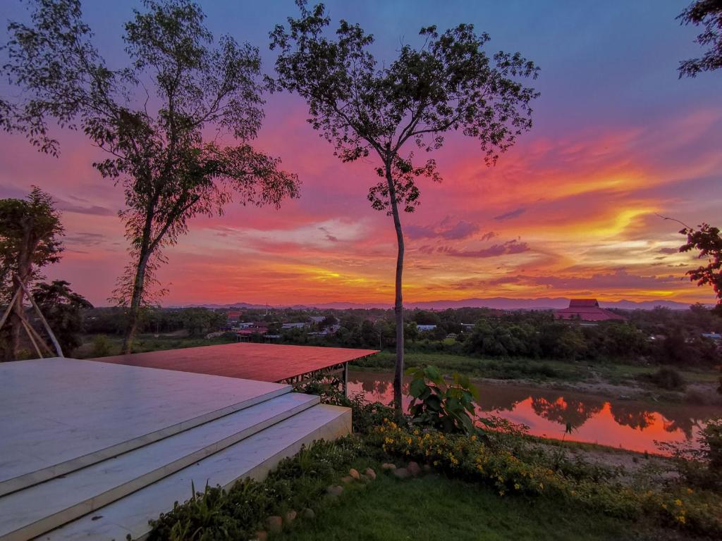 Blick auf den Sonnenuntergang vom Dach eines Hauses in der Unterkunft River Valley Resort in Nan