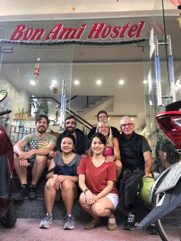 a group of people posing for a picture in front of a store at Bon Ami Hostel in Hue