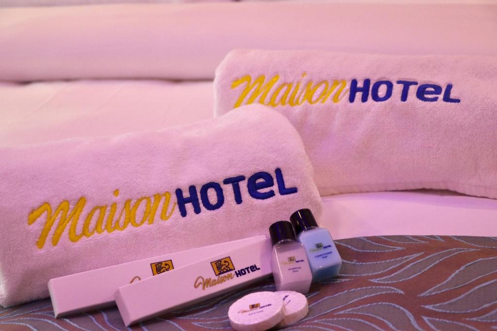 uma cama com duas toalhas e duas garrafas de esmalte de unhas em MAISON HOTEL em Cauayan City