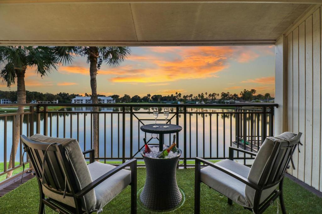 two chairs and a table on a balcony with a view of the water at Saddlebrook Amazing View & Spacious 2 bed/2bath in Wesley Chapel