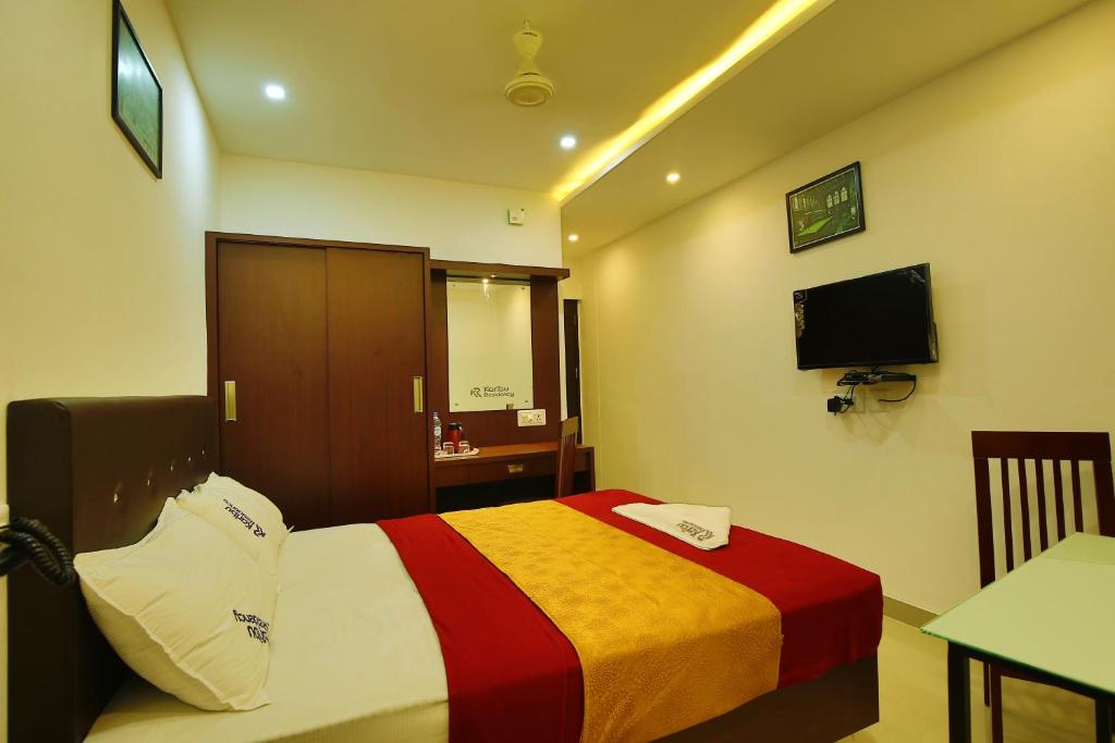 a hotel room with a bed and a television at karibu Residency in Malappuram