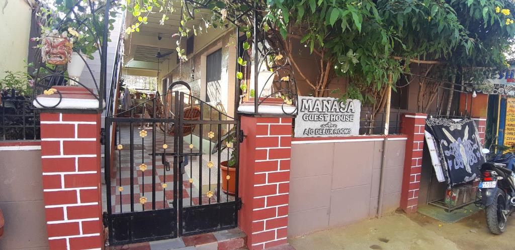 an entrance to a building with a black gate at Manasa guest House in Hampi