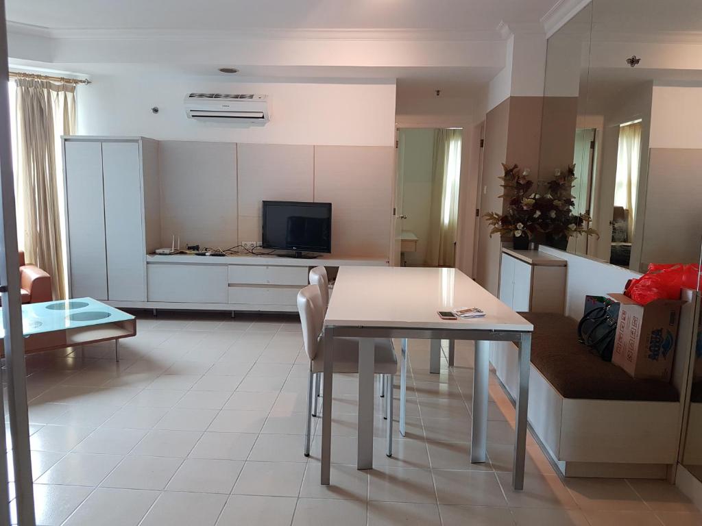 eine Küche und ein Wohnzimmer mit einem Tisch und einem Sofa in der Unterkunft Batavia apartemen in Jakarta