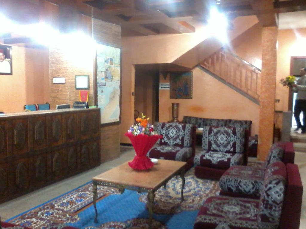 a lobby with a waiting area with chairs and a table at Hotel les palmiers in Agadir