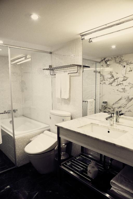 a bathroom with a toilet and a sink and a tub at Reddot Hotel in Taichung