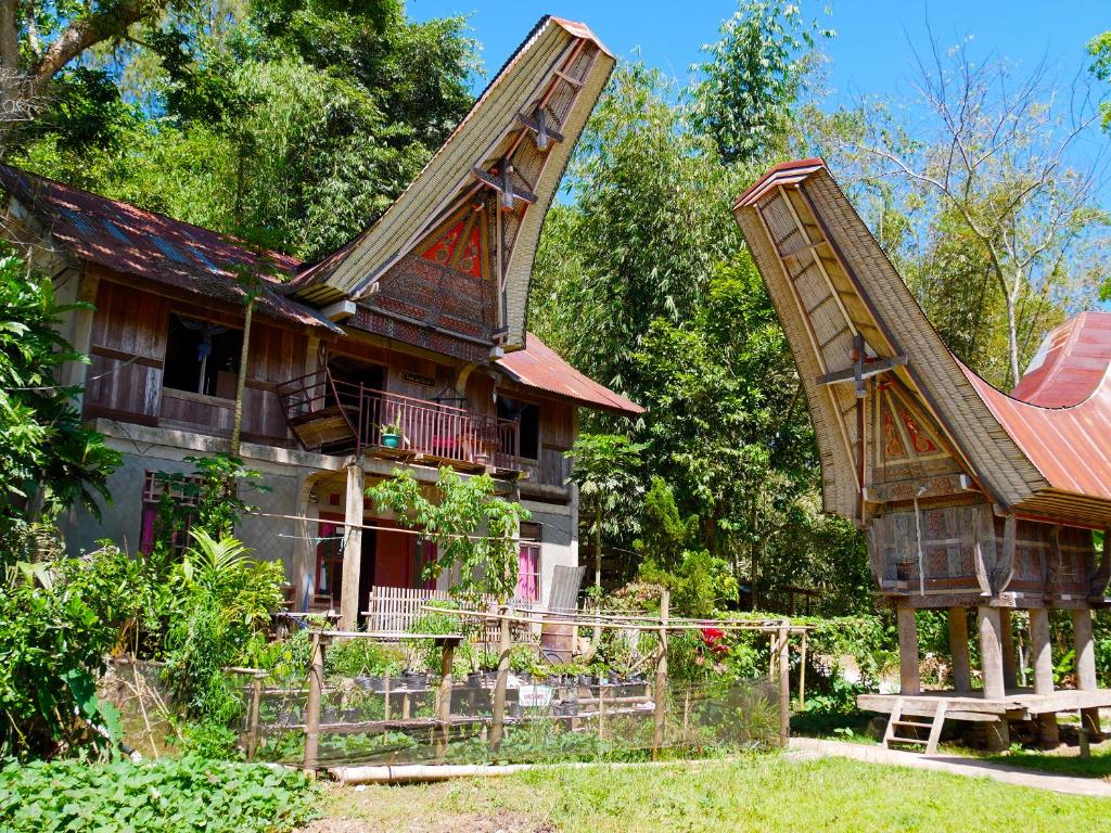 ein altes Haus mit rotem Dach und einer Bank in der Unterkunft Ne Pakku Manja Family Home in Rantepao