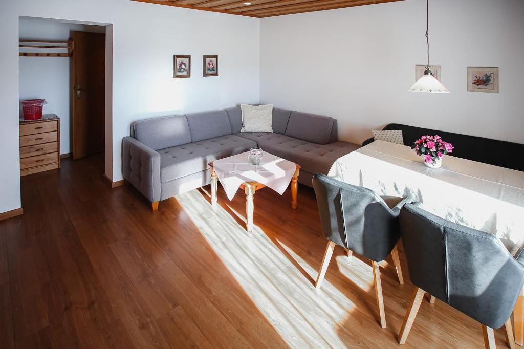 a living room with a couch and a table at Appartements Ferienwohnungen Alpenblick in Faistenau