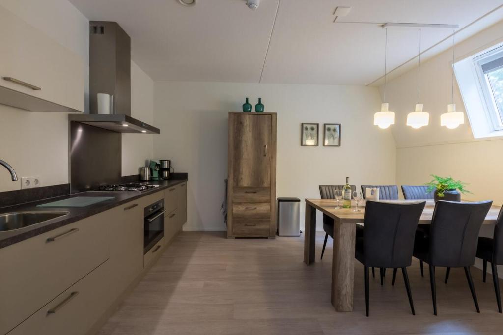 eine Küche und ein Esszimmer mit einem Tisch und Stühlen in der Unterkunft Appartement - Kaapduinseweg 13 Dishoek M Luxe 6 personen in Koudekerke