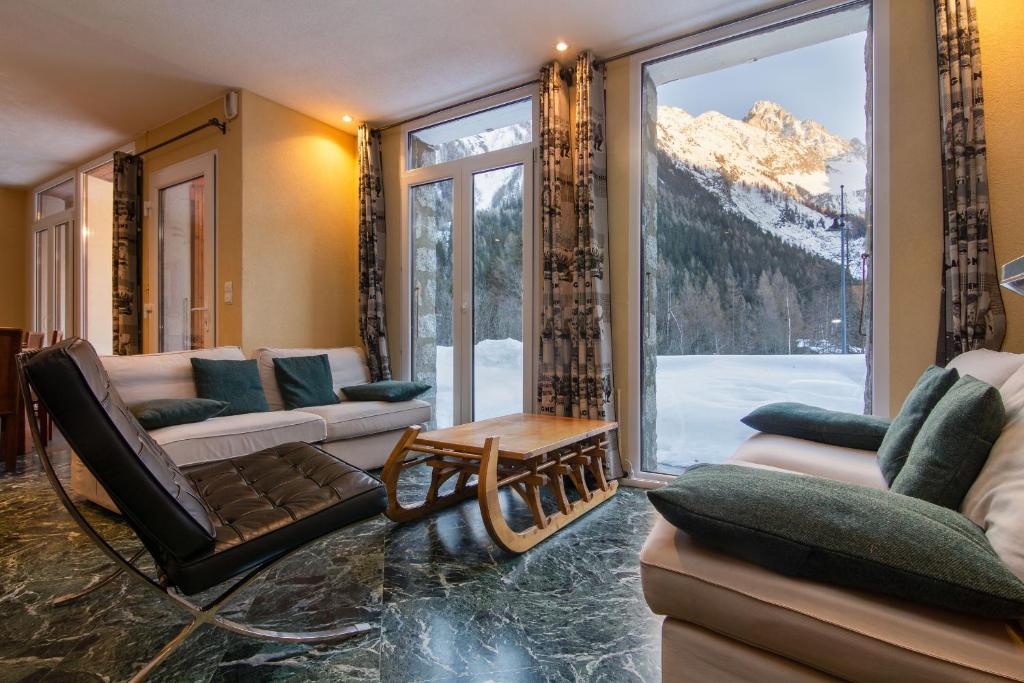 uma sala de estar com sofás e uma grande janela em Chalet Glacier - Happy Rentals em Chamonix-Mont-Blanc
