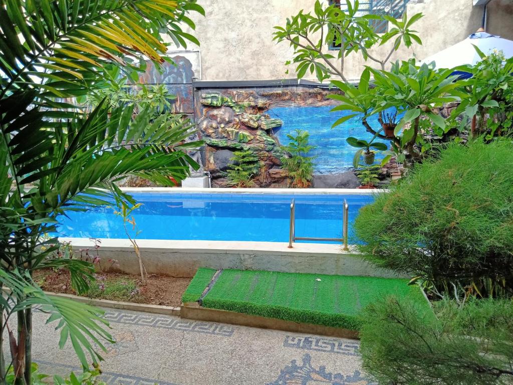 a swimming pool in the middle of a garden at The Mel Homestay in Nusa Penida