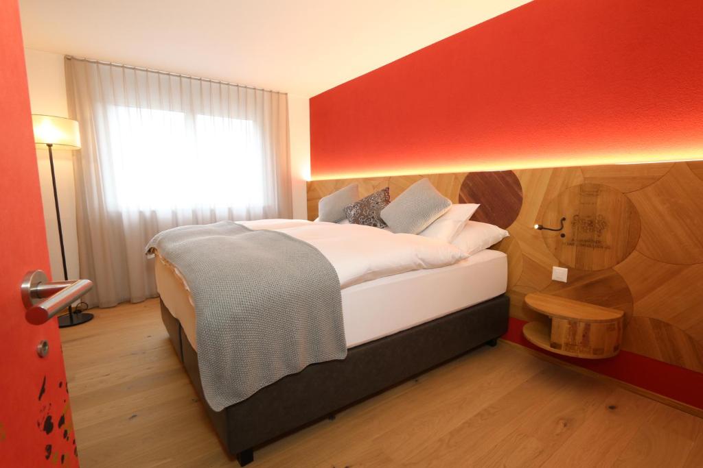 a bedroom with a large bed with a red wall at BnB Vino Veritas in Salgesch