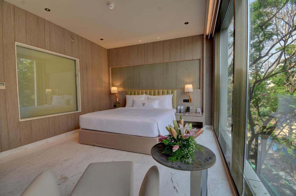 a bedroom with a bed and a table and chairs at Vividus in Bangalore