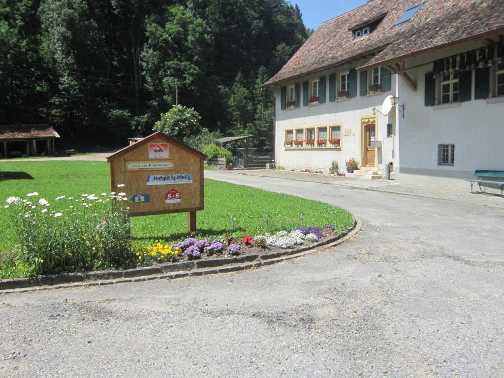 un cartello di fronte a un edificio con fiori di Gast und Hof Spittel a Langenbruck