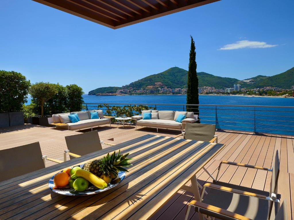 a bowl of fruit on a wooden table on a deck at Dukley Hotel & Resort in Budva