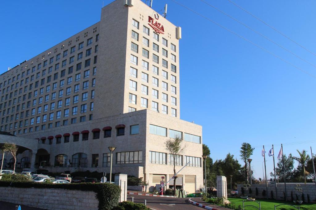 um edifício branco alto com um cartaz em Plaza Nazareth Illit Hotel em Nazaré