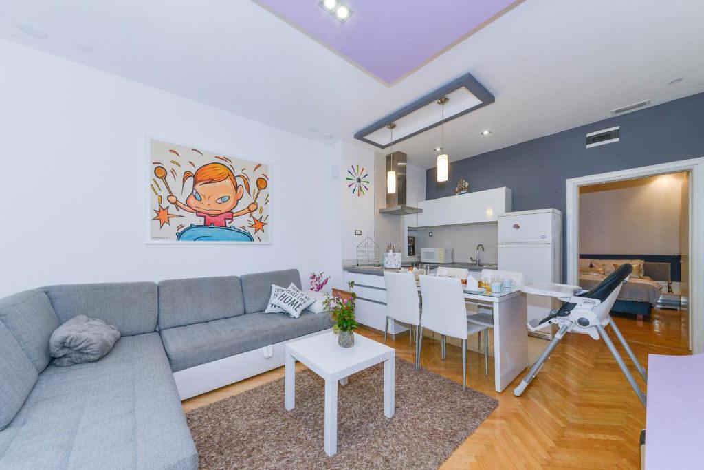 a living room with a gray couch and a kitchen at Family & pet friendly apartment Martina in Promajna