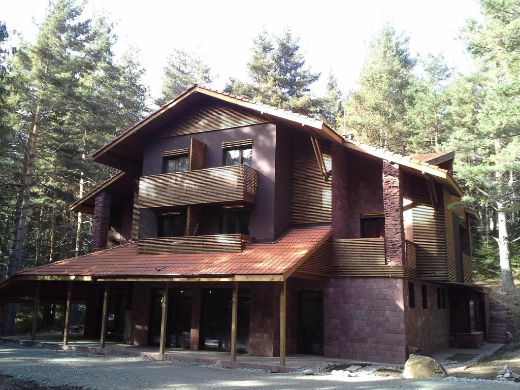 une grande maison en bois dans les bois dans l'établissement Hotel Restaurant 6ATO RiLa, à Panichishte