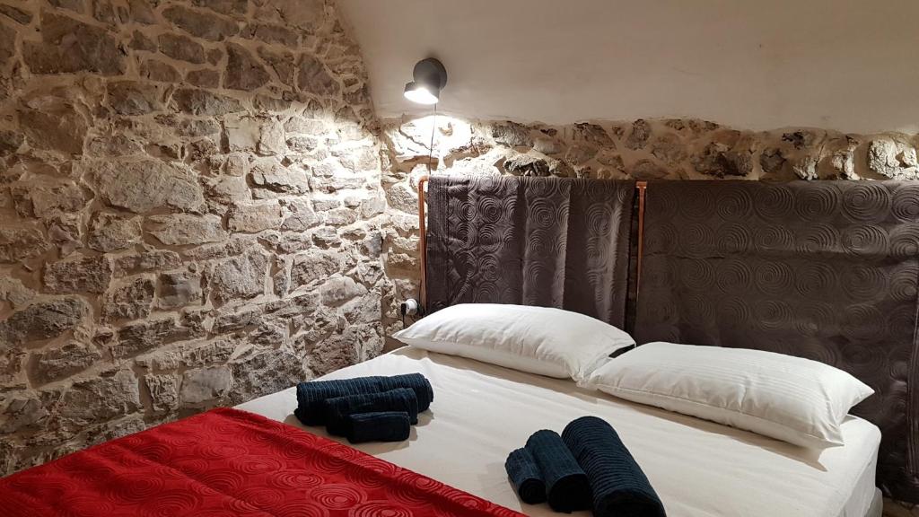 a bed in a room with a stone wall at LA CASA DI ROSA in Rivisondoli