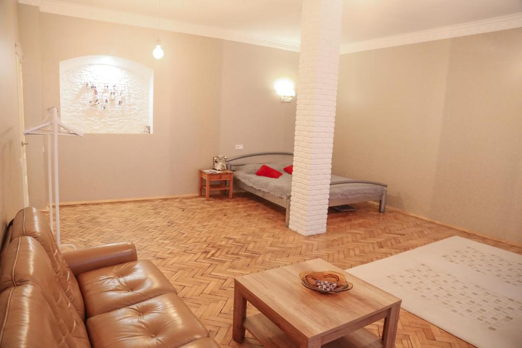 ein Wohnzimmer mit einem Sofa und einem Tisch in der Unterkunft Monro - Heart of Lviv in Lwiw
