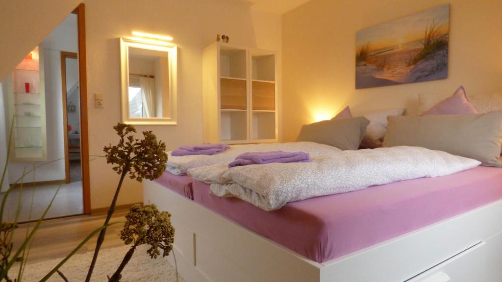 1 dormitorio con 1 cama grande con sábanas moradas en Pension Hohaus en Neuharlingersiel