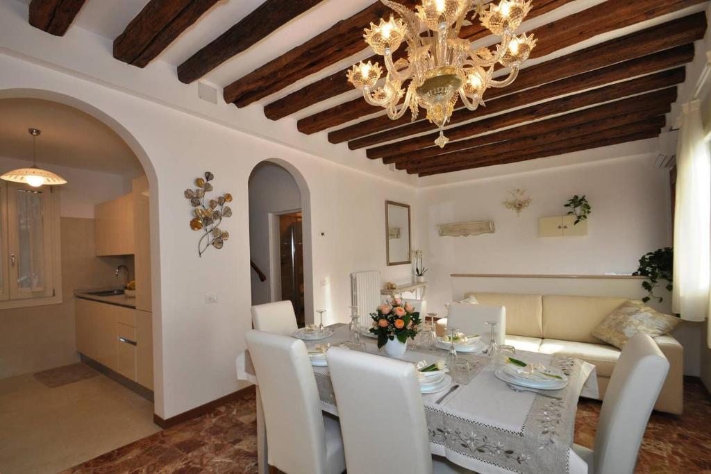 una sala da pranzo con tavolo e lampadario pendente di Ca' Alansari a Venezia