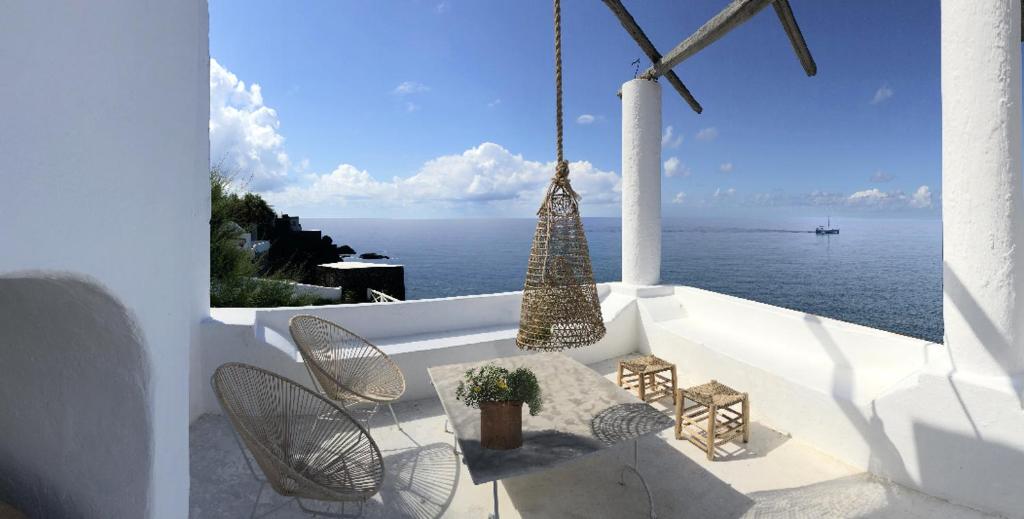 a balcony with chairs and a view of the ocean at Terrazze Fronte Mare e Vulcano in Stromboli