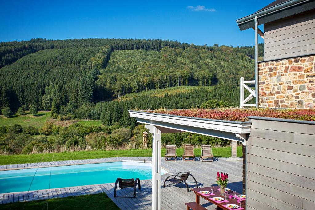 ein Haus mit einem Pool und einer Terrasse in der Unterkunft Le Rêve d'Elise in Stoumont